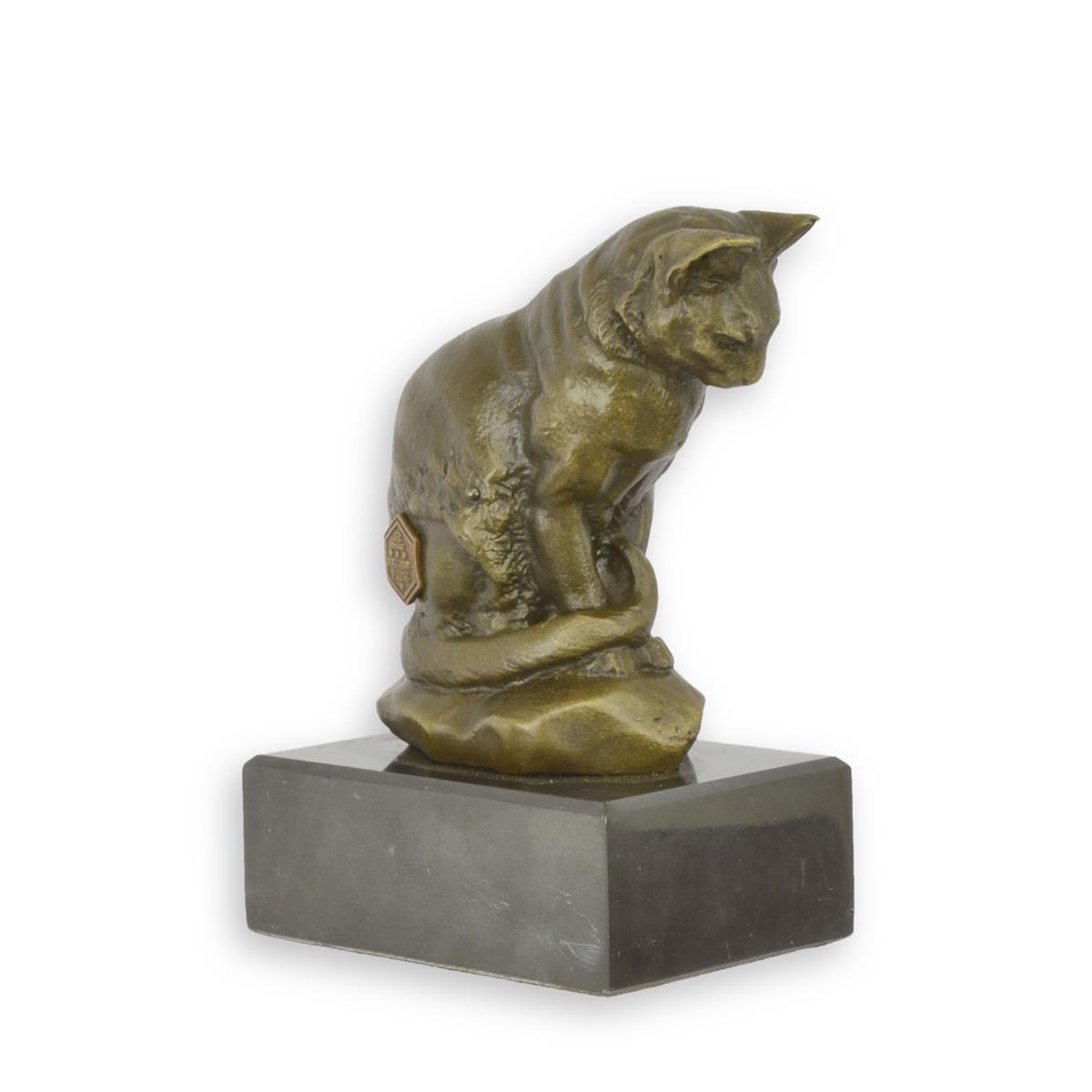 A BRONZE SCULPTURE OF A CAT LOOKING DOWN ON A MARBLE BASE